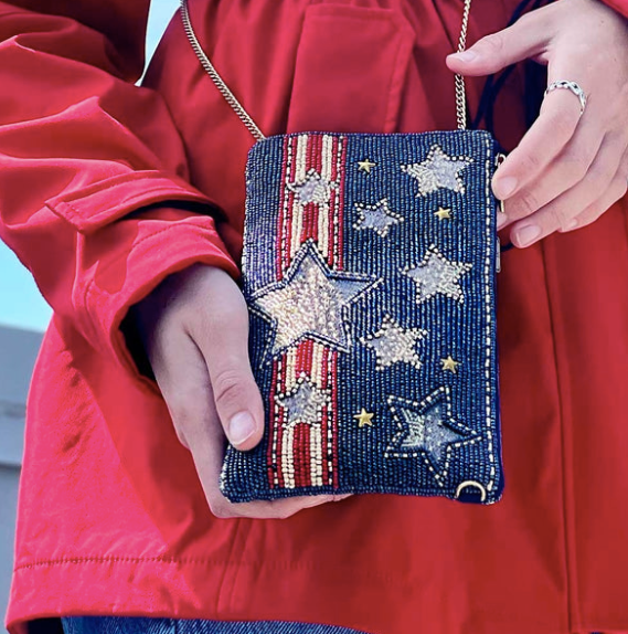 Woman carrying Mary Frances Americana crossbody phone bag 