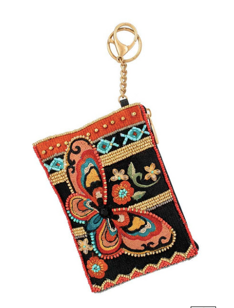 A detailed image of Journey, a beaded and embroidered coin purse key fob by Mary Frances featuring a butterfly and a leather back.